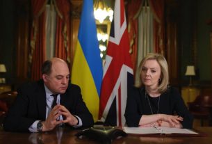 Liz Truss with Ben Wallace, photographed at a desk in front of the Ukraine and Union flags.