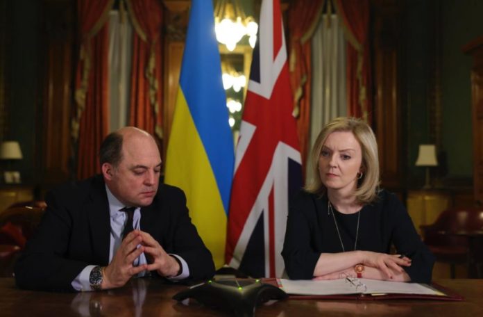 Liz Truss with Ben Wallace, photographed at a desk in front of the Ukraine and Union flags.
