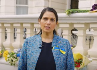 Image shows home secretary Priti Patel wearing a blue and yellow ribbon on her jacket for Ukraine.